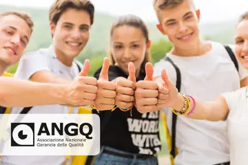Smiling teenagers giving thumbs up outdoors with the ANGQ quality guarantee logo