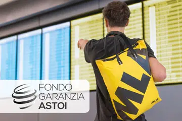 Student with yellow MLA backpack checking an airport departures board, ASTOI logo