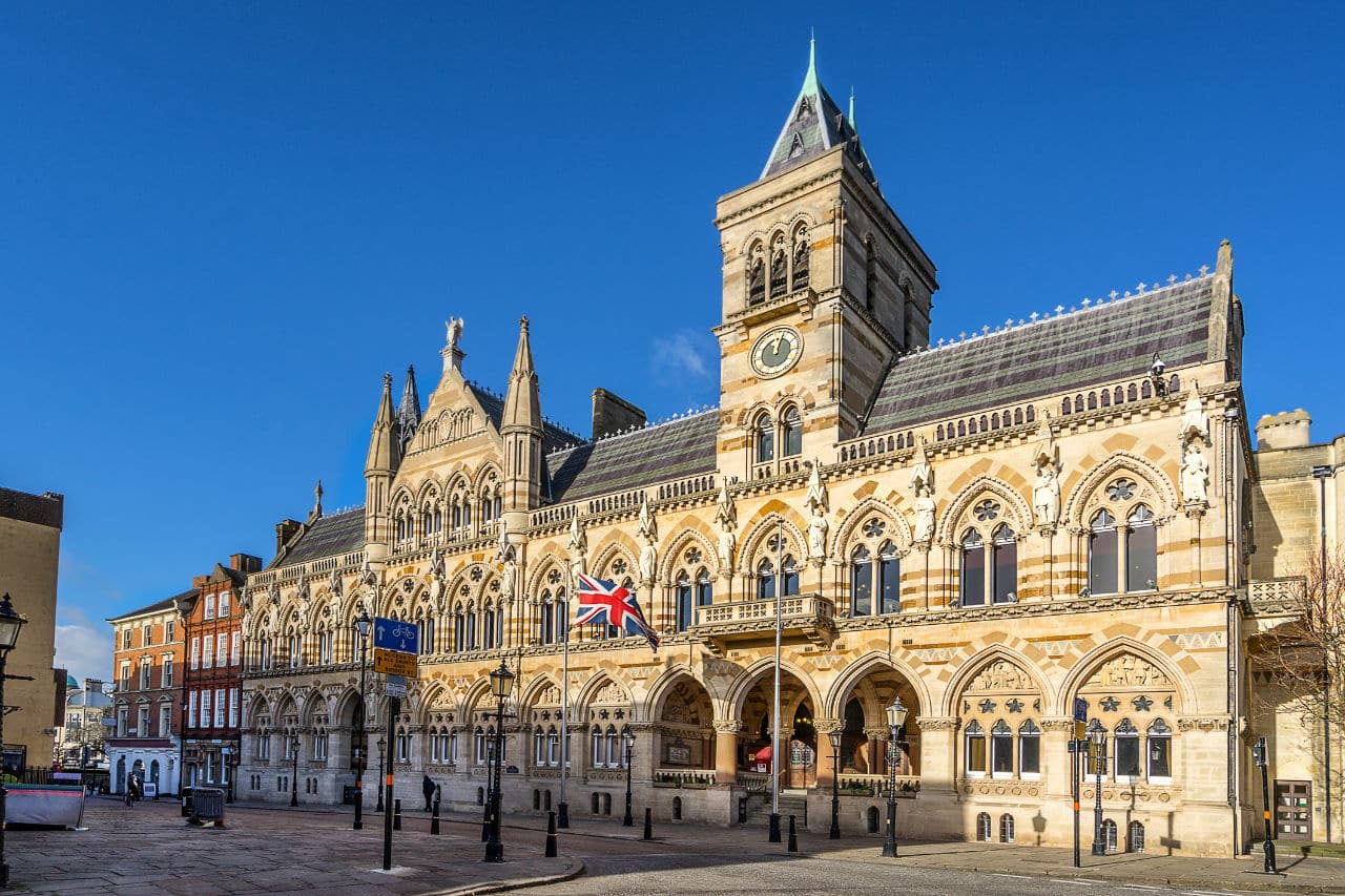 Northampton Guildhall, an ornate Gothic Revival building with clock tower and Union Jack flag