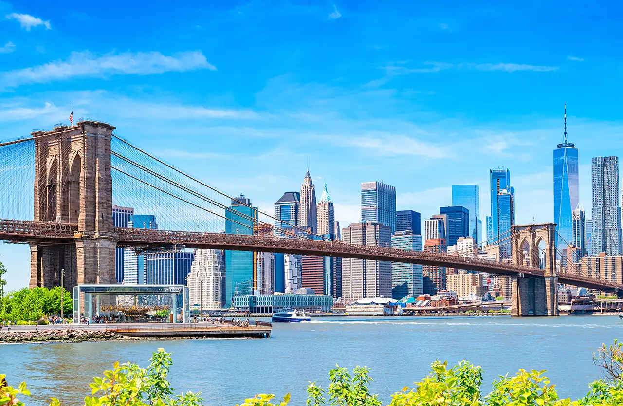 Brooklyn Bridge and the Lower Manhattan skyline under a blue sky