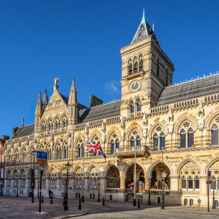 Northampton Guildhall, an ornate Gothic Revival building with clock tower and Union Jack flag