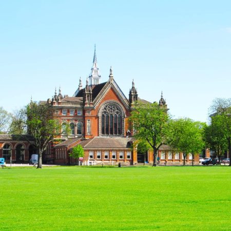 Dulwich College red-brick Victorian buildings and clock tower beyond a wide green lawn